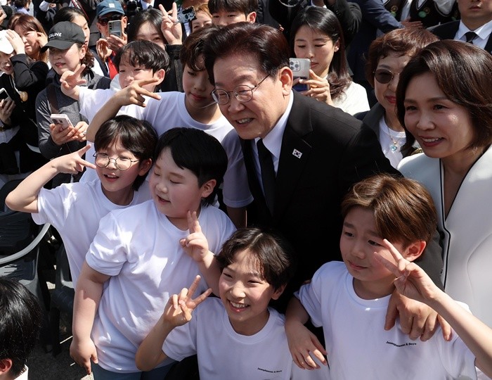 이재명 대통령과 김혜경 여사가 19일 서울 강북구 수유동 국립4·19민주묘지에서 열린 제66주년 4·19혁명 기념식을 마친 뒤 참가 학생들과 기념 촬영을 하고 있다. / 뉴스1