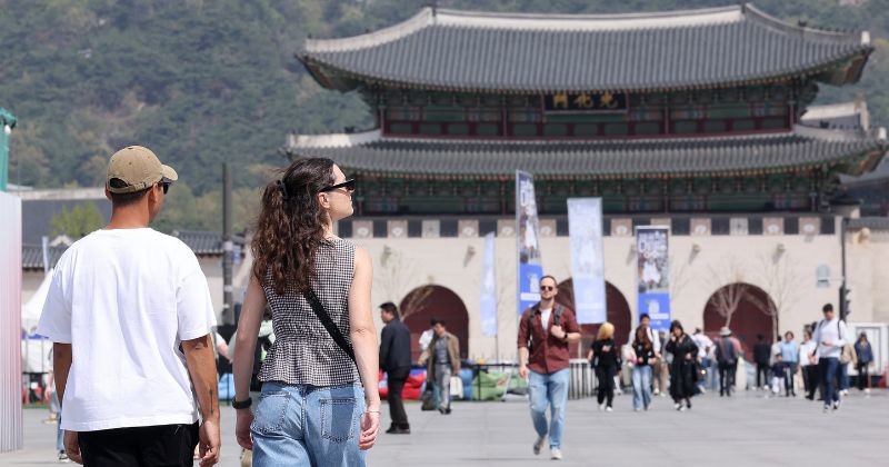 경복궁을 배경으로 외국인 관광객들이 서울의 역사적 명소를 둘러보고 있는 모습. / 뉴스1