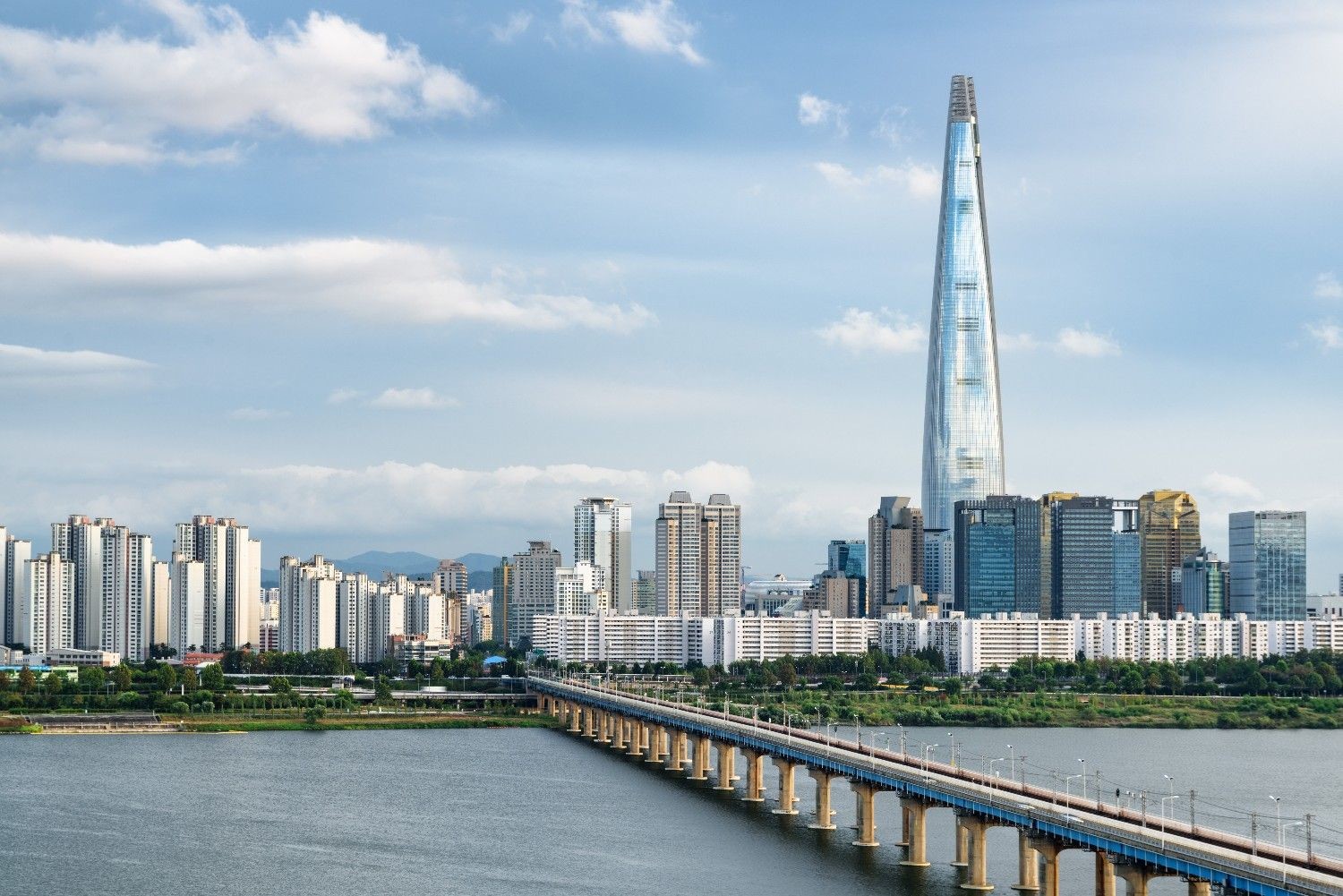 한강 위로 길게 뻗은 다리와 함께 서울의 대표 랜드마크인 롯데월드타워가 도심 스카이라인을 압도적으로 장식하고 있는 모습. / 셔터스톡
