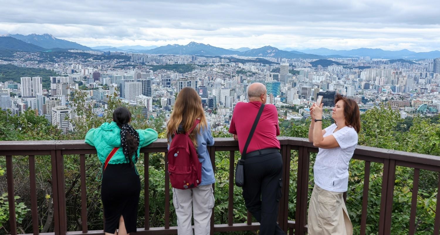 서울 도심을 내려다보는 전망대에서 외국인 방문객들이 도시 전경을 바라보는 모습으로, ‘살아보고 싶은 도시’로서의 서울 이미지를 상징적으로 보여주는 장면. / 뉴스1