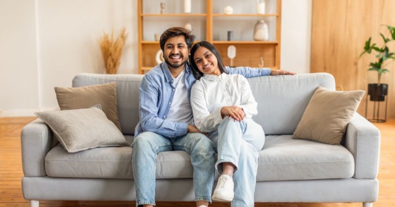 남성과 여성이 거실의 소파에 편안하게 앉아 있다. 앞에 놓인 커피 테이블과 바닥에 놓인 아늑한 양탄자를 놓고 대화를 나눈다. / 셔터스톡