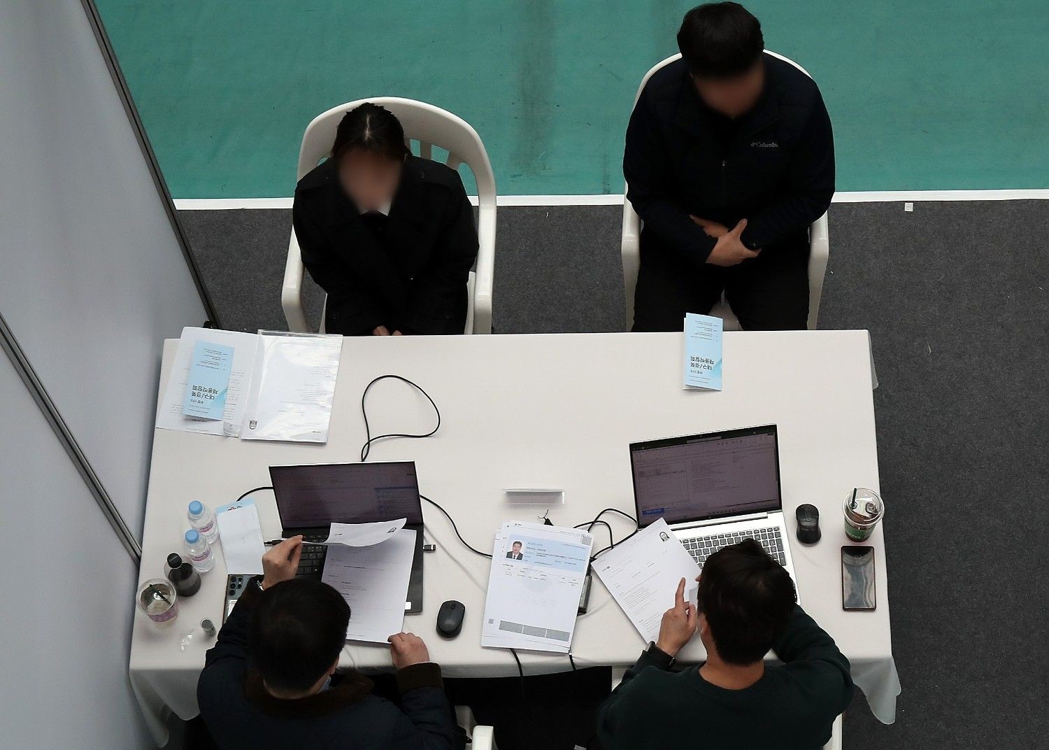 면접 시작 전 지원자들이 앉은 상태에서 인사하는 장면으로, 한국 면접에서 중요한 예절과 태도를 상징적으로 보여주는 이미지. / 뉴스1