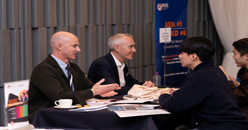 QS 박람회에서 행사 참가자가 학교 담당자와 대화를 나누고 있다 / MBA 박람회
