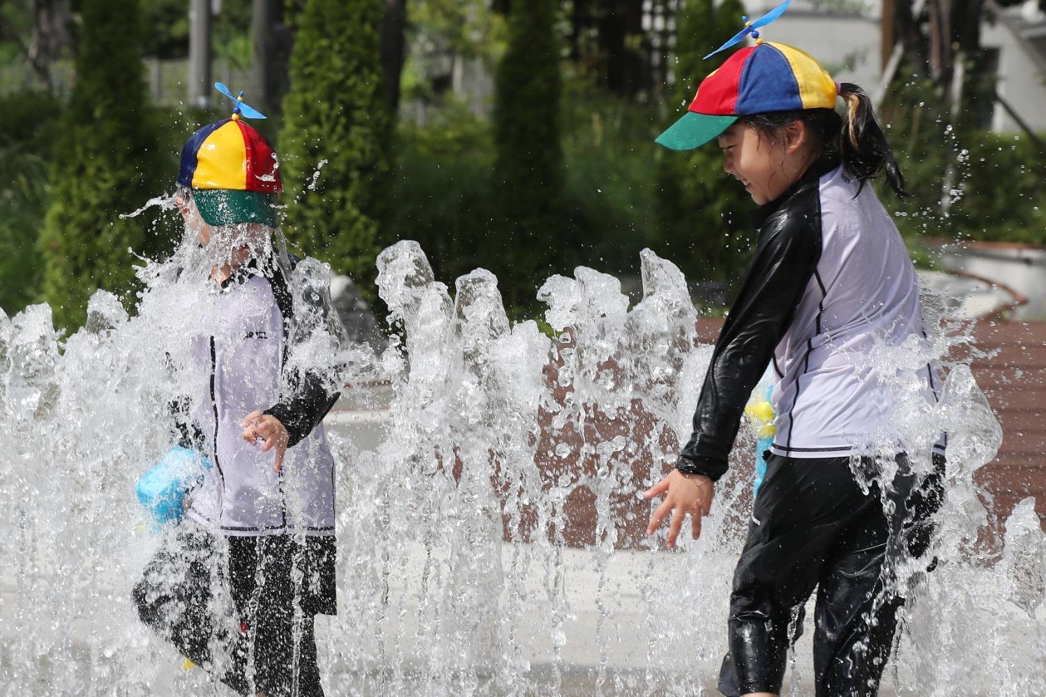 더운 날씨 속에서 분수대 물놀이를 즐기는 아이들의 모습으로, 한국 여름의 높은 기온과 이를 식히기 위한 일상적인 풍경을 담고 있다. / 뉴스1