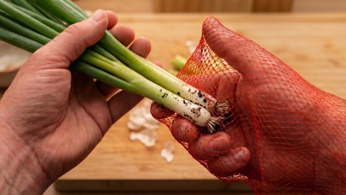 기사를 바탕으로 AI가 생성한 자료사진. 양파망을 손에 끼운다. 다른 한쪽 손에 쪽파를 잡고 양파망이 씌워진 손으로 가볍게 밀어주듯 문질러주면 껍질을 제거할 수 있다. 쪽파 외에도 도라지, 생강 등에도 활용할 수 있다.