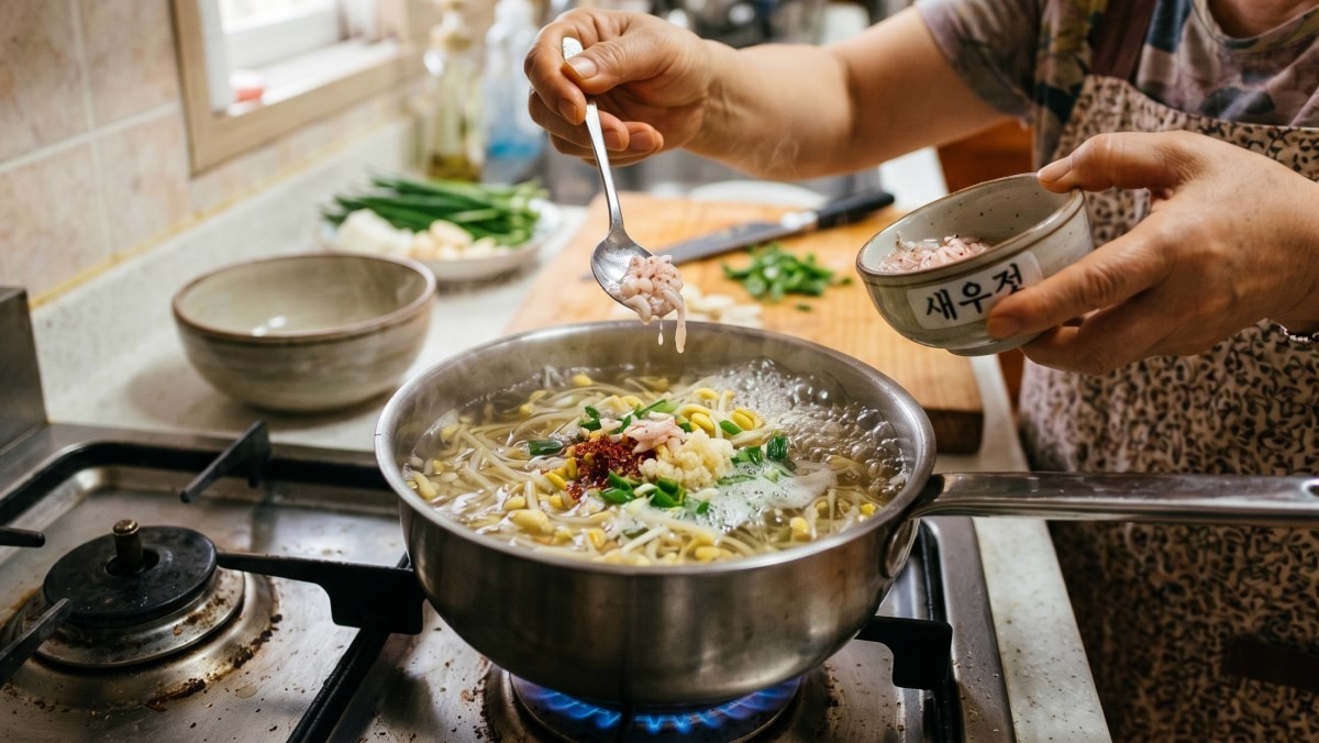 콩나물국에 새우젓을 넣는 모습 (AI로 제작)