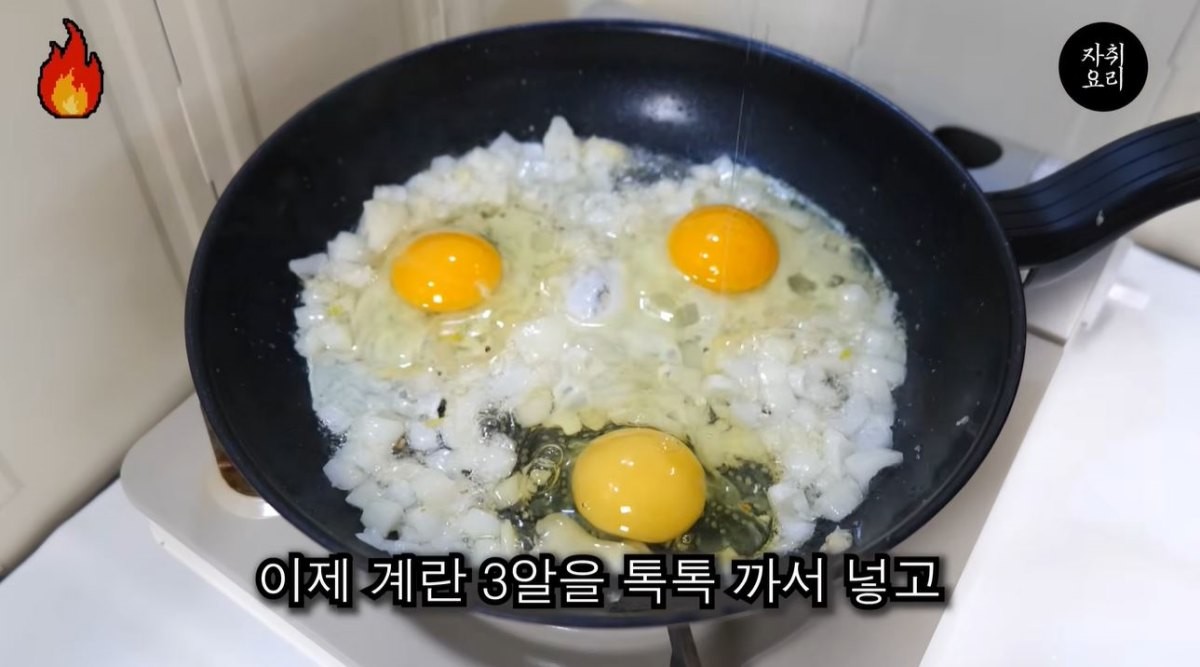 양파와 다진마늘을 볶은 후 계란 세 알을 깨 넣은 모습. / 유튜브 '자취요리신 simple cooking'