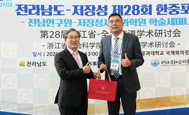 강상구 나주시장 권한대행(왼쪽)과 왕위 저장성사회과학원 부원장(오른쪽)이 기념품을 주고받고 있다.