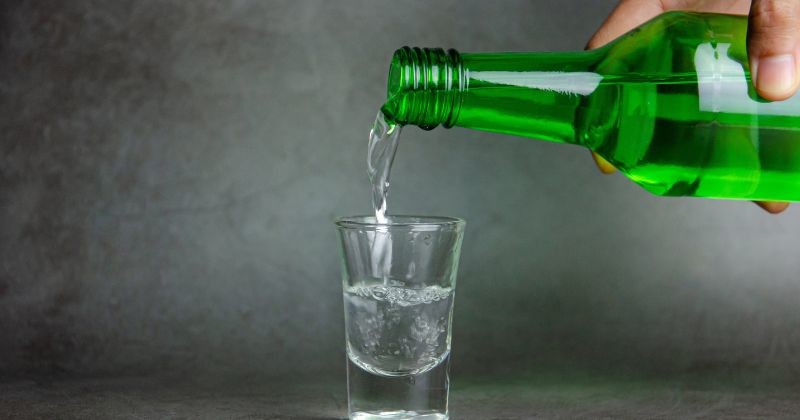 술잔에 소주가 쏟아지고, 선택적으로 초점을 맞추다 / 셔터스톡