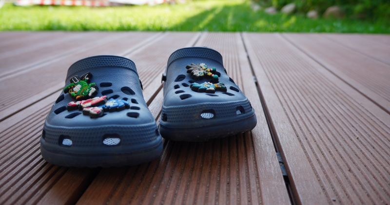 나무 데크에 Hedgehog Jibbitz 소닉과 블루 크록스 클록스 / 셔터스톡