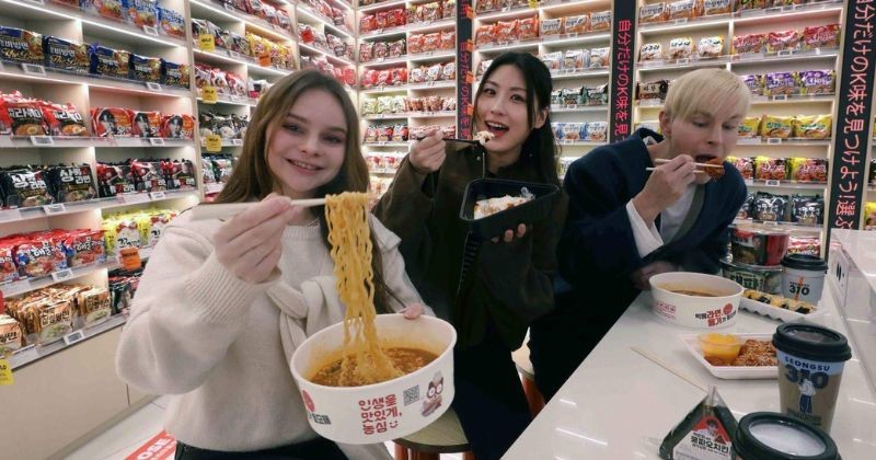 라면 전문 콘셉트 공간에서 외국인들이 다양한 한국 라면을 직접 먹어보는 모습으로, K-푸드 체험 공간으로 확장된 편의점 문화의 새로운 트렌드를 보여준다. / 뉴스1