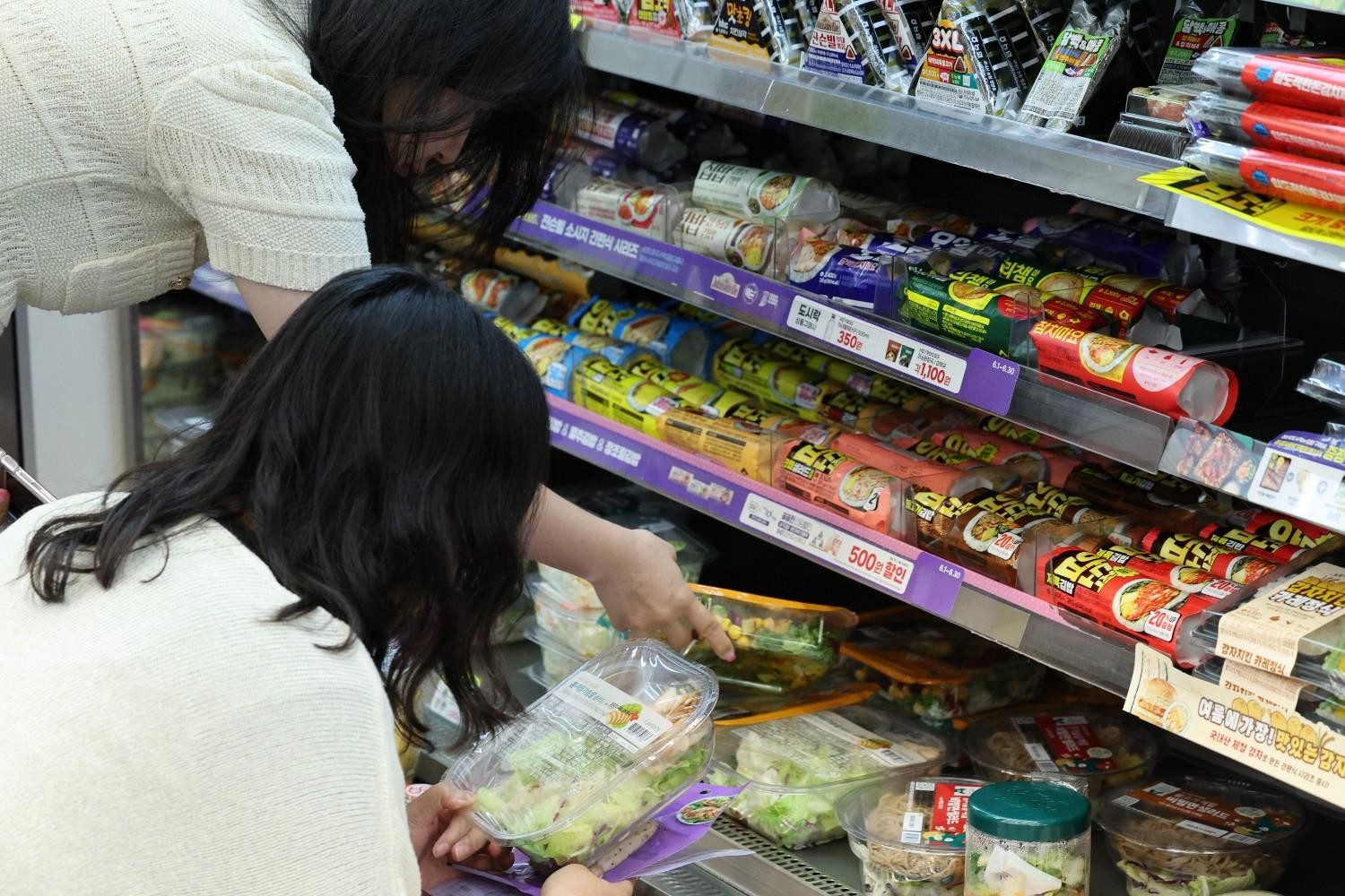 편의점 신선식품 코너에서 샐러드와 간편식을 고르는 모습으로, 다양한 다이어트 식단과 간편식 옵션을 한 번에 비교하며 선택할 수 있는 한국 편의점의 특징을 보여준다. / 뉴스1