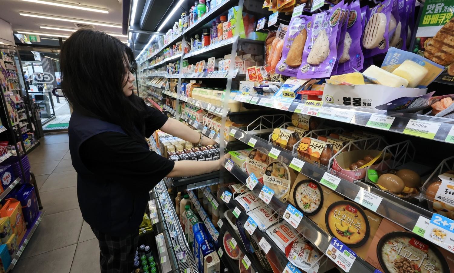 편의점 냉장 코너에서 도시락과 간편식을 고르는 장면으로, 즉석에서 데워 먹을 수 있는 식사형 제품이 풍부하게 준비된 한국 편의점 문화를 나타낸다. / 뉴스1