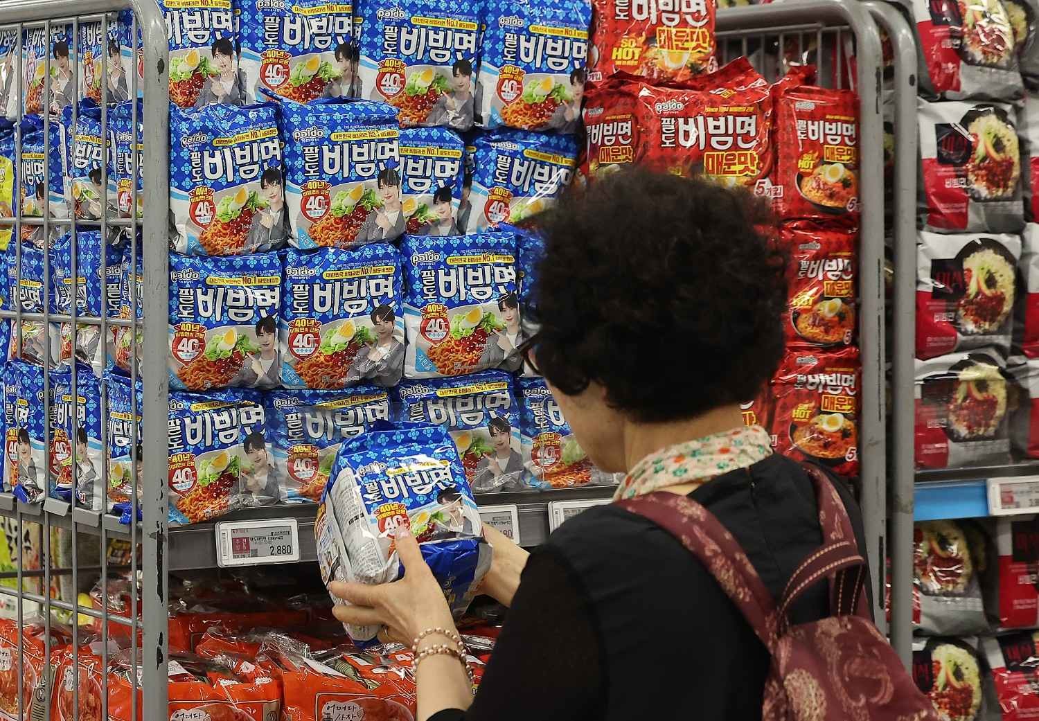 라면 코너에서 다양한 브랜드와 맛을 비교하며 제품을 고르는 모습으로, 한국 편의점과 마트에서 볼 수 있는 압도적인 라면 종류의 다양성을 잘 보여준다. / 뉴스1