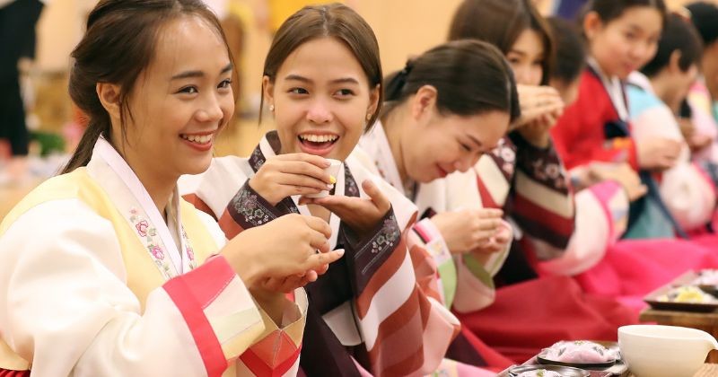 한복을 입은 외국인들이 전통 음식을 즐기며 밝게 웃고 있는 모습. 한국 문화 체험 속에서 자연스럽게 드러나는 언어와 소통의 순간이 인상적이다. / 뉴스1