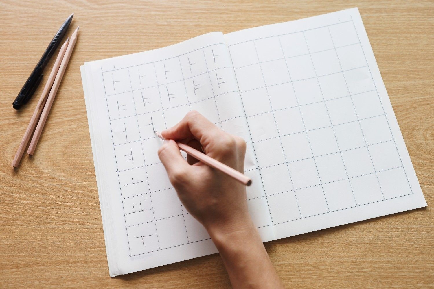 한글 연습 노트에 자음을 반복해서 쓰며 한국어를 익히고 있는 장면. 낯선 문자 체계를 배우는 외국인의 집중된 모습이 담겨 있다. / 셔터스톡