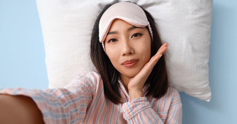 수면 안대를 착용한 채 침대에 누워 편안한 표정을 짓고 있는 모습. / 셔터스톡