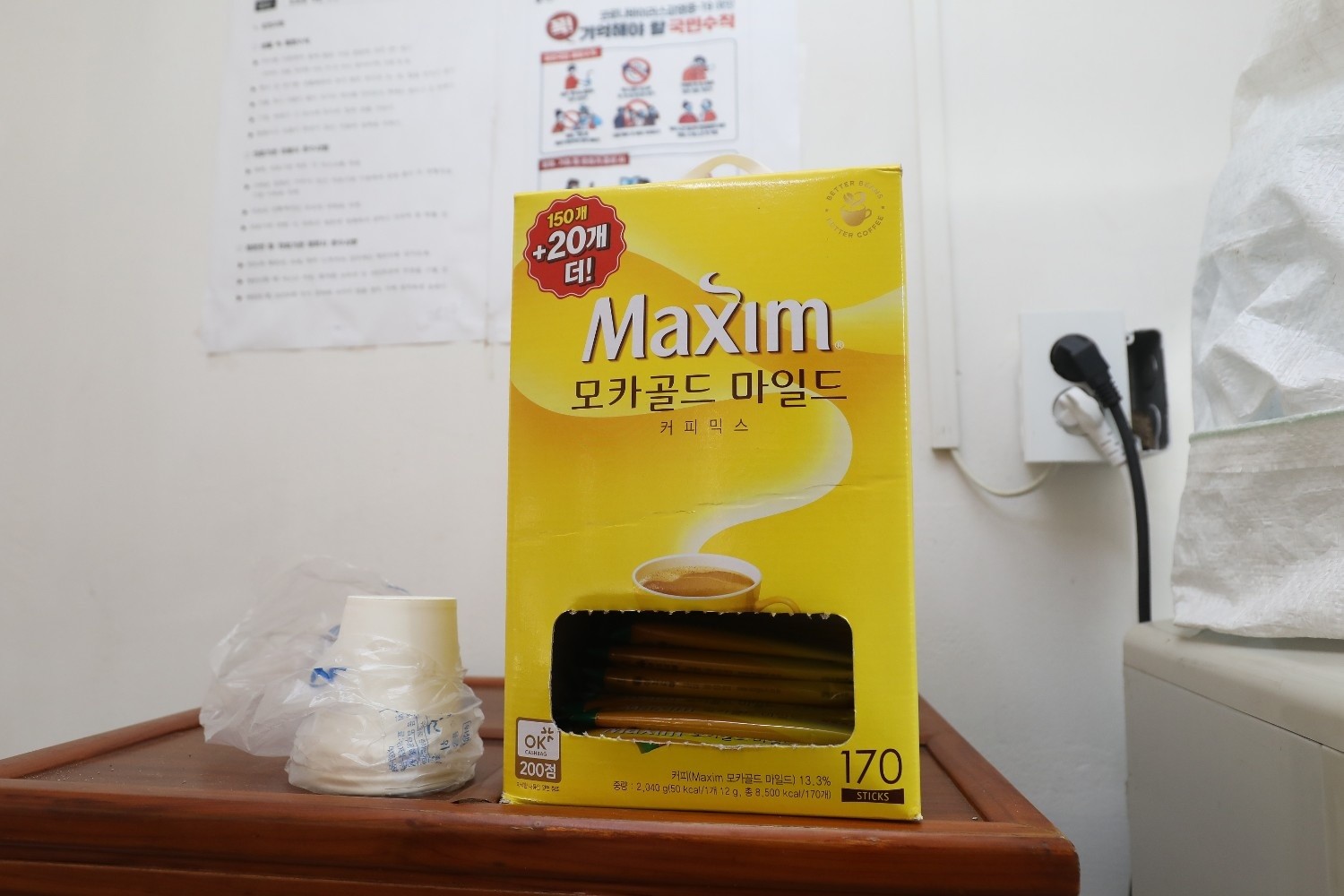 책상 위에 놓인 ‘맥심 모카골드 마일드’ 믹스커피 박스와 일회용 컵. / 뉴스1