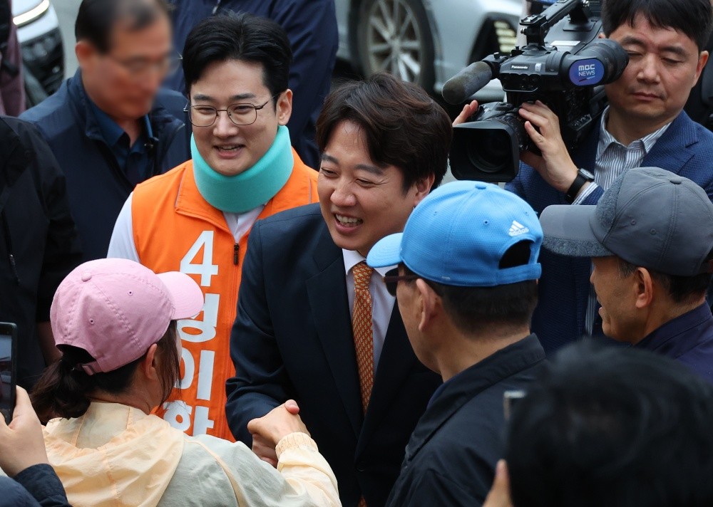 개혁신당 이준석 대표와 정이한 부산시장 후보가 29일 부산 북구 구포시장을 찾아 시민들과 인사하고 있다. 정이한 후보는 전날 시민이 던진 음료수를 피하다 다쳐 석고붕대를 하고 있다. / 연합뉴스