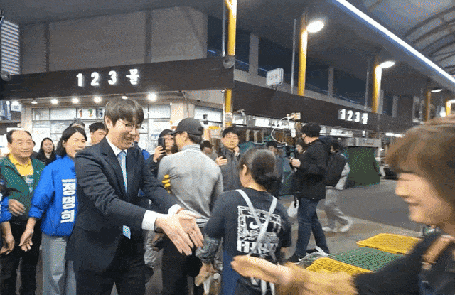 이하 하정우 전 청와대 인공지능(AI) 미래기획수석이 첫 일정으로 29일 부산 북구 구포시장을 찾아 상인과 악수를 나눈 뒤 손을 터는 모습.  / 온라인 커뮤니티