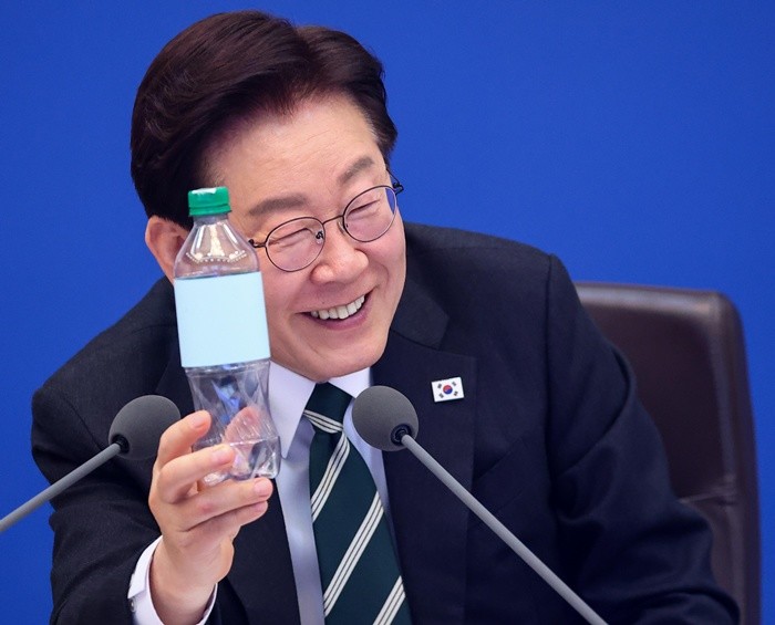 이재명 대통령이 28일 청와대에서 열린 국무회의 겸 비상경제점검회의에서 재생원료를 100% 사용한 페트병을 살펴보고 있다. 2026.4.28/뉴스1