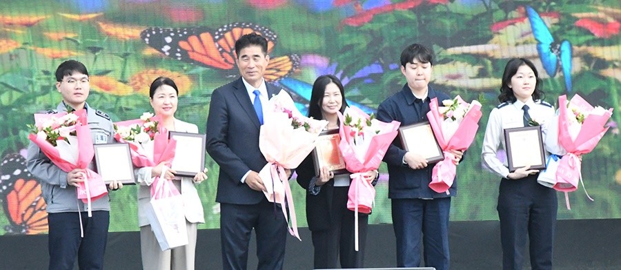 함평군은 4일 엑스포공원 나비대축제 주무대(잔디광장)에서 ‘제48회 함평군민의 날 기념식’을 개최했다.  오민수 함평군번회장이 모범공무원에게 감사패 전달하고 기념촬영을 하고 있다. / 노해섭 기자