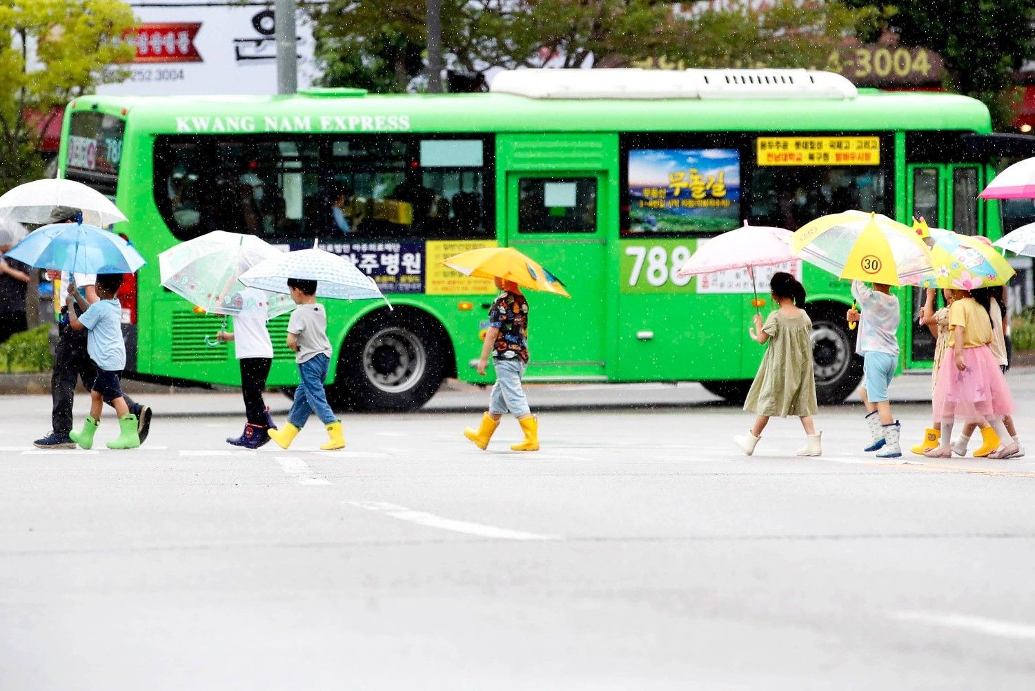 장맛비가 내리는 거리에서 아이들이 형형색색 우산과 장화를 신고 횡단보도를 건너고 있다. / 뉴스1