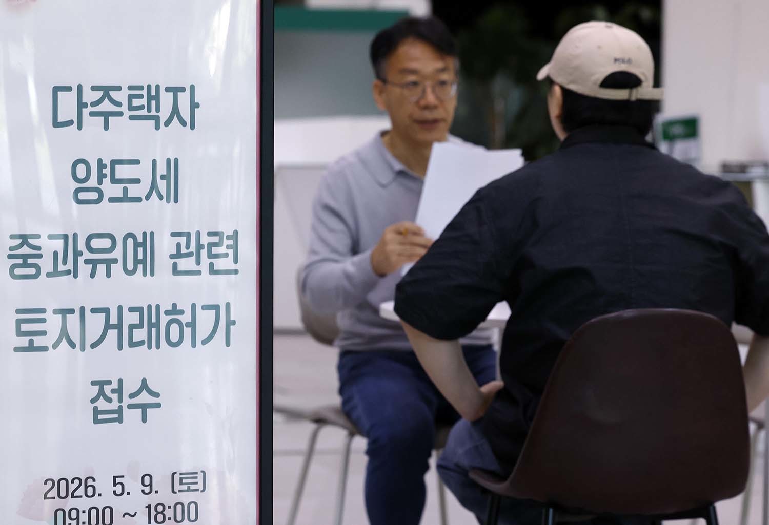 다주택자 양도소득세 중과 유예 종료 시한인 9일 오전 서울시 송파구 송파구청 1층에 마련된 다주택자 양도세 중과유예 관련 토지거래허가 접수처를 찾은 시민들이 부동산정보과 공무원들에게 서류 검토를 받고 있다. 정부가 이날까지 토지거래허가만 신청해도 중과 대상에서 제외하기로 하면서 다주택자 양도소득세 중과 유예 종료 시한인 5월 9일 토요일 서울 25개 구청이 문을 열었다.  / 뉴스1