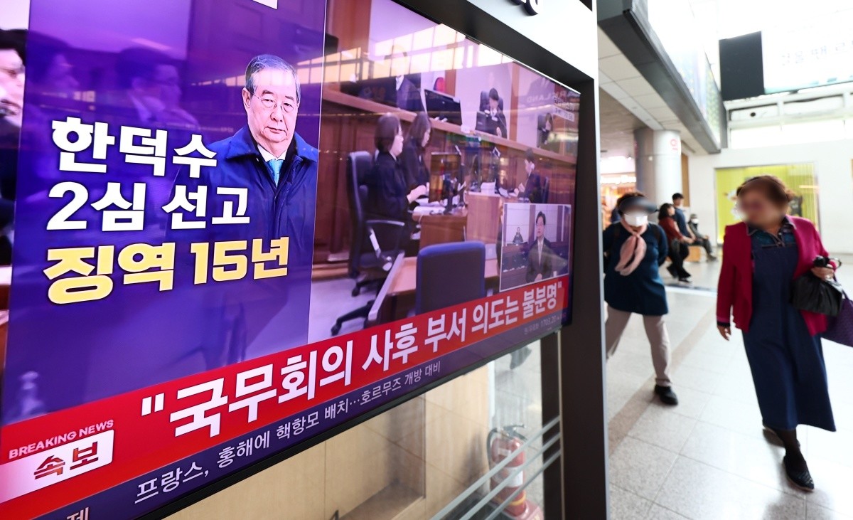 지난 7일 오전 서울 용산구 서울역 대합실에서 시민들이 12.3 비상계엄 사태와 관련해 내란 중요임무 종사 혐의를 받는 한덕수 전 국무총리의 항소심 선고 공판 관련 뉴스를 지켜보고 있다. 한 전 총리는 지난 1심 징역 23년 보다 8년 낮은 징역 15년형을 선고 받았다. / 뉴스1
