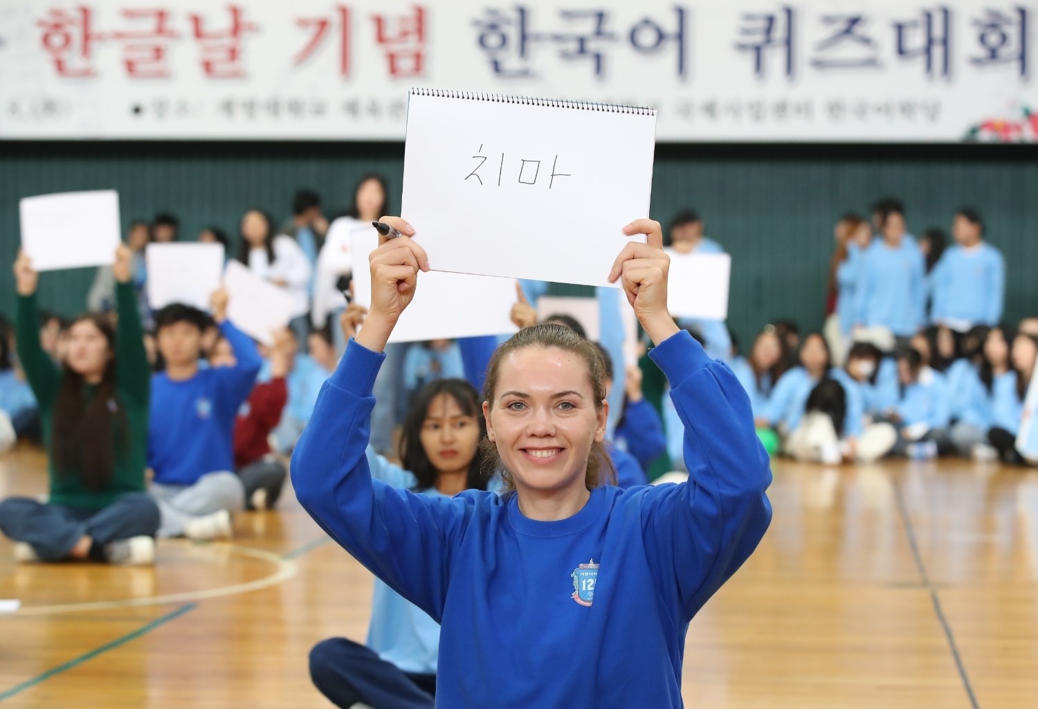 외국인 참가자가 한글날 기념 한국어 퀴즈대회에서 직접 한글 단어를 적어 보이며 환하게 웃고 있다. / 뉴스1