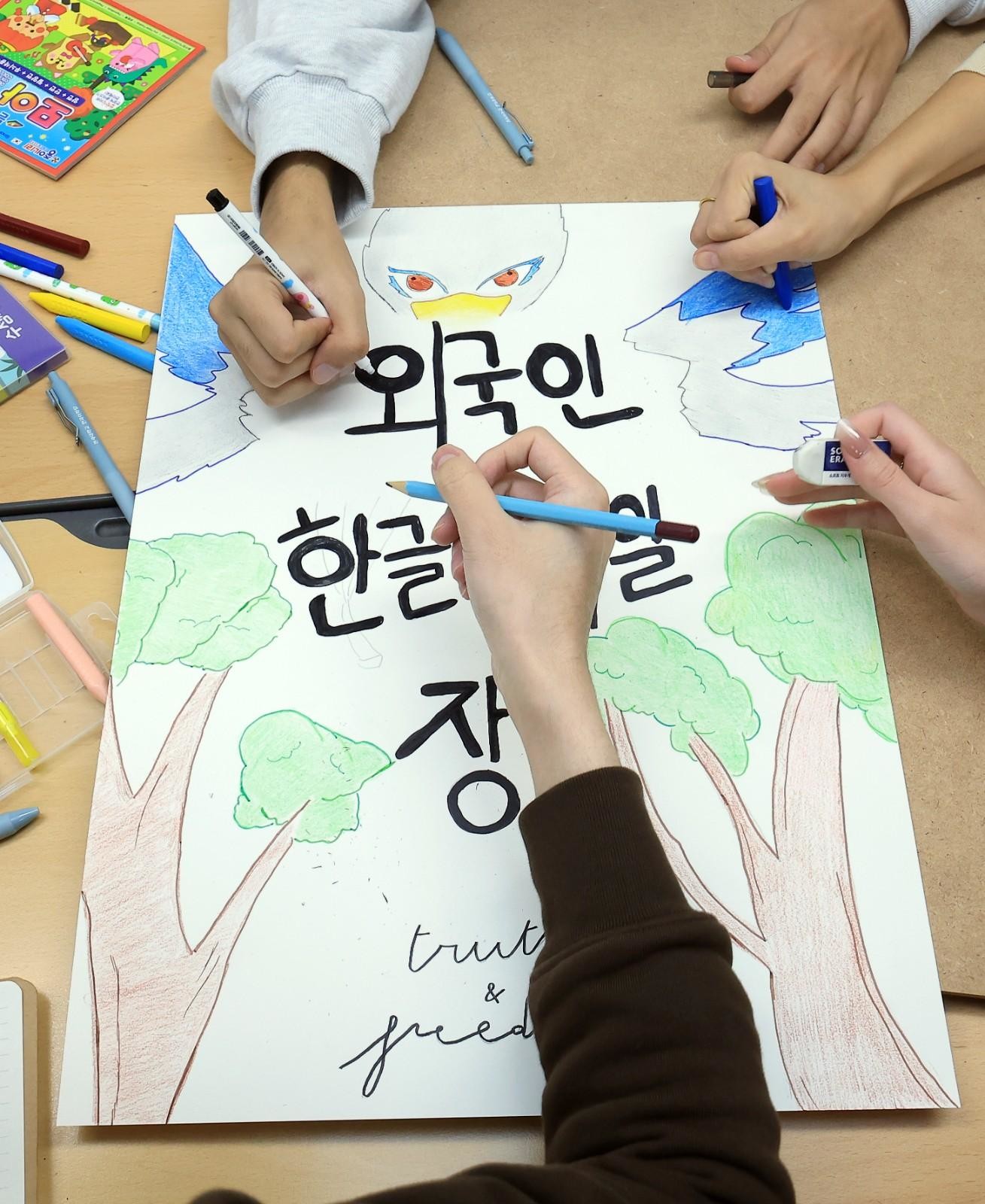참가자들이 한글 문구와 그림이 담긴 손그림 포스터를 함께 완성하고 있다. / 뉴스1
