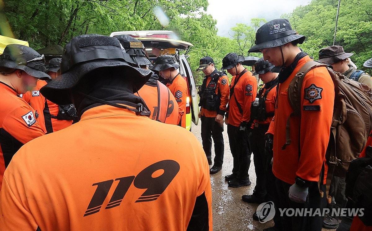 실종된 초등학생이 숨진 채 발견된 지난 12일 경북 청송군 주왕산국립공원에서 소방 구조대가 구조 완료와 동시에 묵념하고 있다 / 연합뉴스