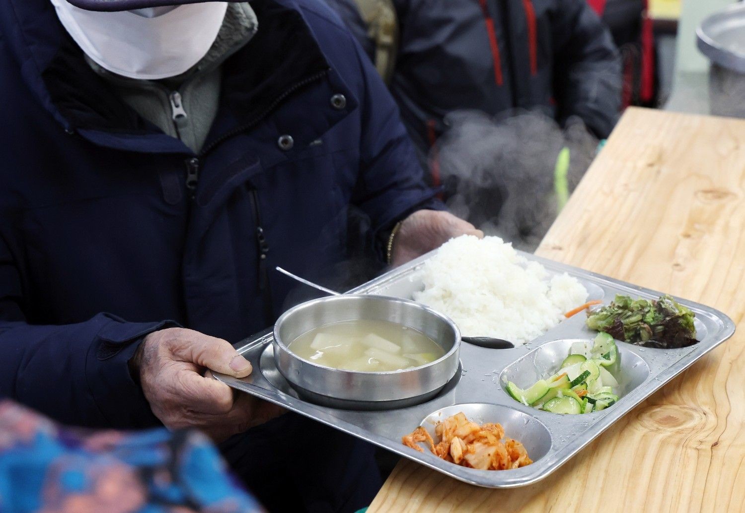 한 노인이 무료 급식소에서 따뜻한 식사를 받고 있는 모습. / 뉴스1
