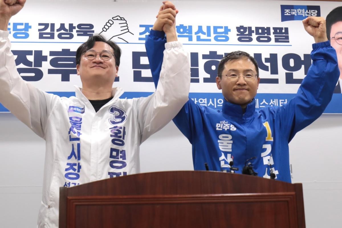 황명필 조국혁신당 울산시장 후보(왼쪽)와 김상욱 더불어민주당 울산시장 후보가 14일 울산시의회 프레스센터에서 후보 단일화 선언 회견을 열고 손을 맞잡고 있다.  / 뉴스1