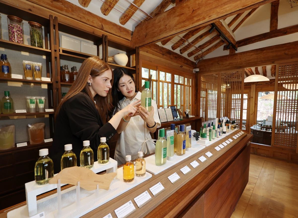 서울 종로구 북촌한옥마을에 새로 오픈한 스칼프·스킨 케어 브랜드 아로마티카의 플래그십 스토어 '아로마티카 북촌'에서 직원이 방문객에게 제품을 소개하고 있다.  / 연합뉴스