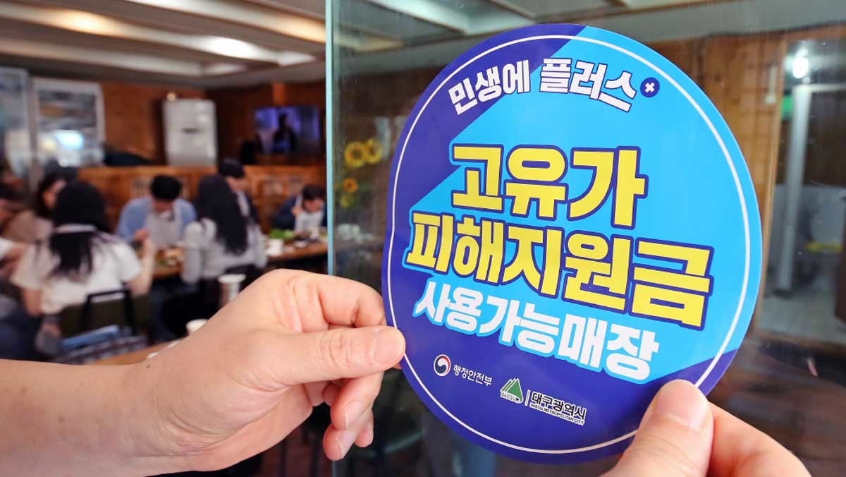 대구 수성구 한 음식점에서 상인이 고유가 피해지원금 사용 가능 매장을 알리는 스티커를 붙이고 있다. / 뉴스1