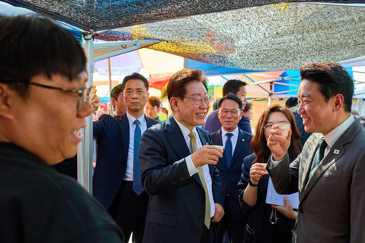 이재명 대통령이 지난 14일 성남 모란시장에서 강훈식 비서실장과 시식을 하며 대화하고 있다 / 청와대 제공, 연합뉴스