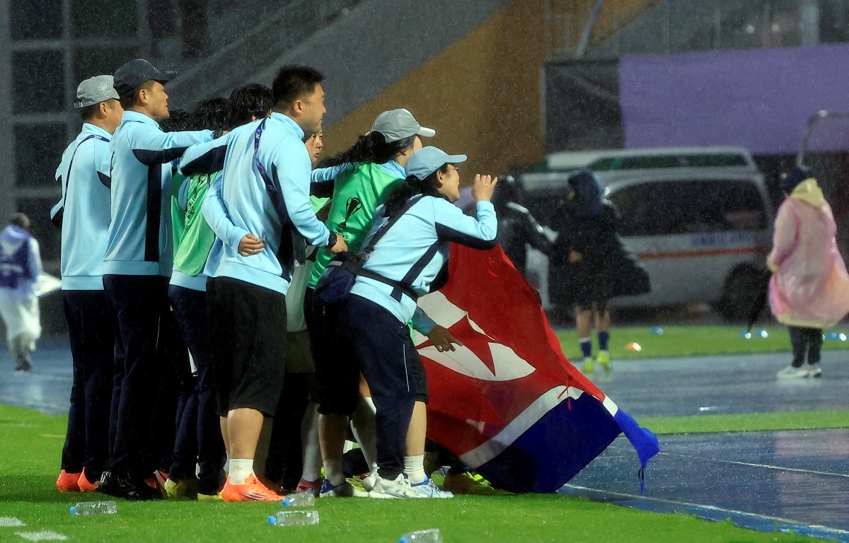 20일 오후 경기도 수원시 장안구 경수대로 수원종합운동장에서 열린 2025-2026 아시아축구연맹(AFC) 여자 챔피언스리그(AWCL) 4강 수원FC 위민과 북한 내고향여자축구단의 경기에서 2대1로 승리한 북한 내고향여자축구단 선수와 코칭스태프가 인공기를 펼쳐 기념 촬영을 하고 있다. / 뉴스1