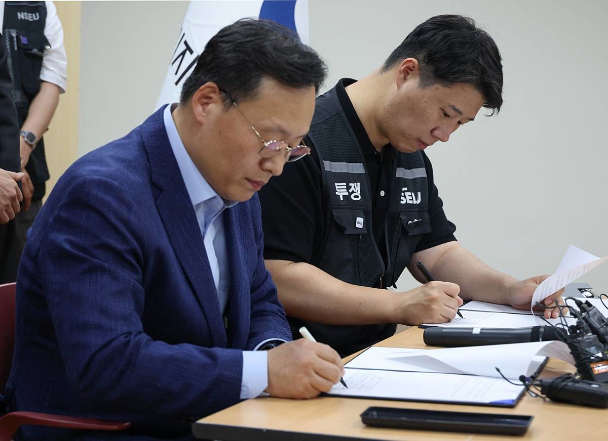 여명구 삼성전자 DS(디바이스솔루션·반도체 사업 담당) 피플팀장(왼쪽)과 최승호 삼성그룹 초기업노동조합 삼성전자지부 위원장이 전날 오후 경기 수원시 장안구 경기지방고용노동청에서 열린 삼성전자 노사교섭 결과 브리핑에서 합의안에 서명을 하고 있다 / 뉴스1