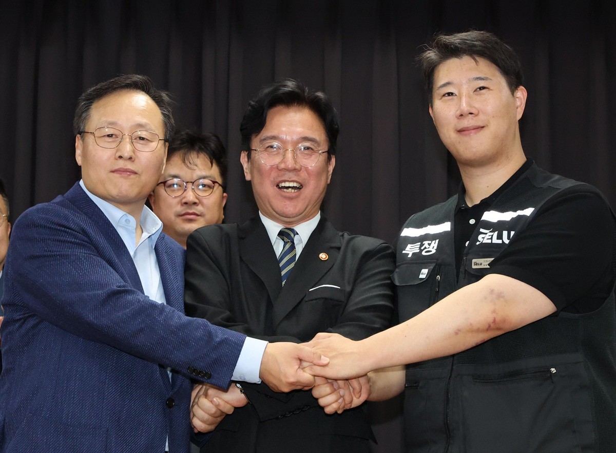 20일 경기 수원시 장안구 경기고용노동청에서 열린 삼성전자 임금협상을 마친 후 여명구 삼성전자 DS(디바이스솔루션·반도체 사업 담당) 피플팀장(왼쪽부터)과 김영훈 고용노동부 장관, 최승호 삼성그룹 초기업노동조합 삼성전자지부 위원장이 잠정 합의안에 서명한 후 손을 맞잡고 있다. / 뉴스1