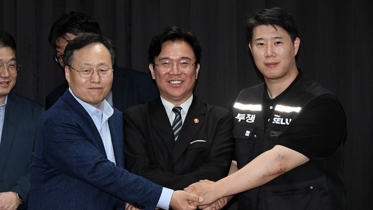 지난 20일 경기도 수원시 장안구 경기고용노동청에서 열린 삼성전자 임금협상을 마친 후 여명구 삼성전자 DS(디바이스솔루션·반도체 사업 담당) 피플팀장과 김영훈 고용노동부 장관, 최승호 삼성그룹 초기업노동조합 삼성전자지부 위원장이 잠정 합의한에 서명한 후 손을 맞잡고 있는 모습 / 뉴스1