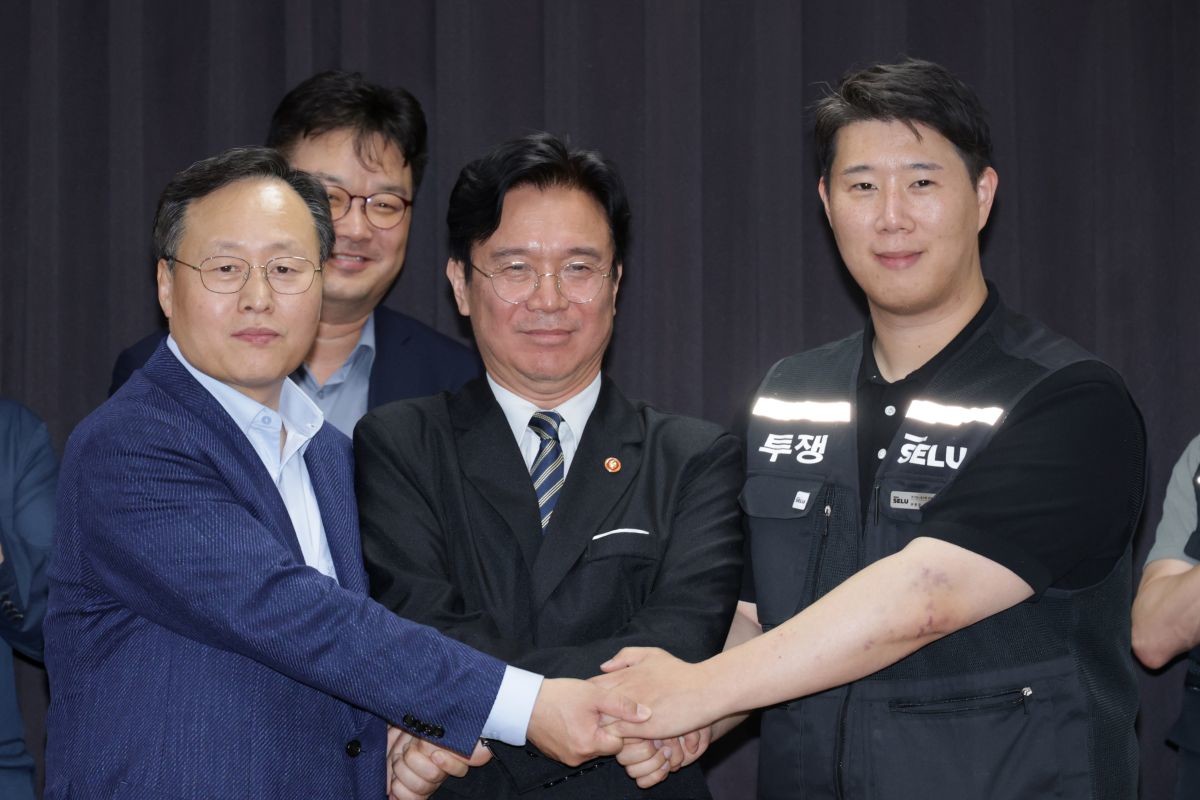 지난 20일 경기도 수원시 장안구 경기고용노동청에서 열린 삼성전자 임금협상을 마친 후 여명구 삼성전자 DS(디바이스솔루션·반도체 사업 담당) 피플팀장과 김영훈 고용노동부 장관, 최승호 삼성그룹 초기업노동조합 삼성전자지부 위원장이 잠정 합의한에 서명한 후 손을 맞잡고 있다. / 공동취재-뉴스1