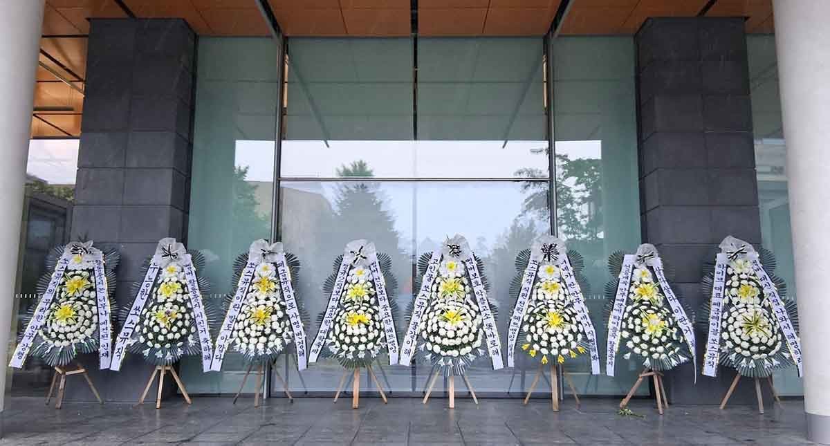 서울 용산구 하이브 사옥 인근 도로에 르세라핌 팬들이 보낸 근조화환이 줄지어 서 있다. / 더쿠