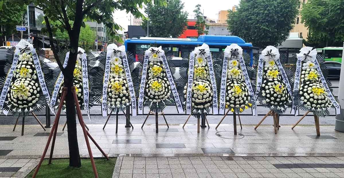 서울 용산구 하이브 사옥 인근 도로에 르세라핌 팬들이 보낸 근조화환이 줄지어 서 있다. / 더쿠