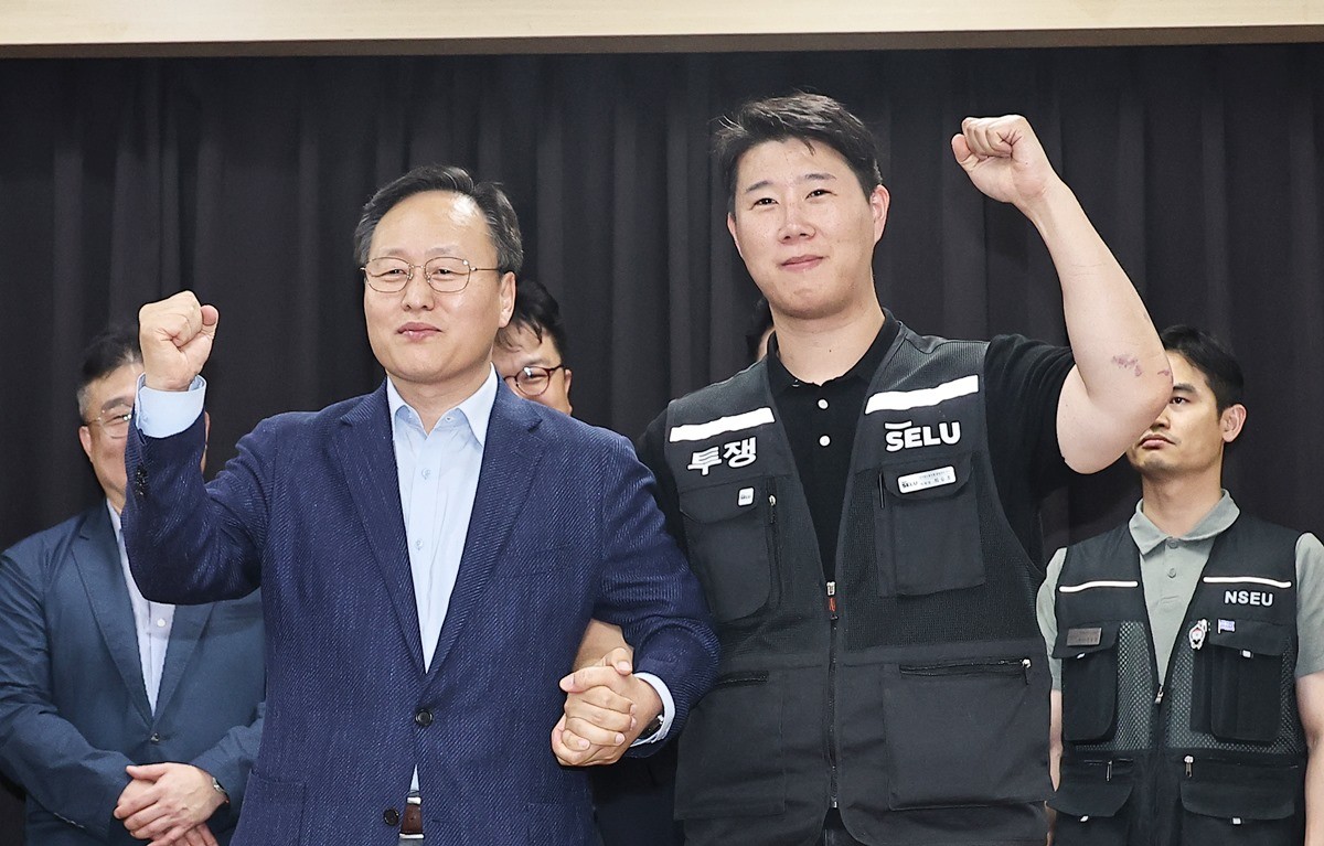 삼성전자 임금협상을 마친 뒤 여명구 삼성전자 DS(반도체 사업 담당) 피플팀장과 최승호 삼성그룹 초기업노동조합 삼성전자지부 위원장이 잠정 합의한에 서명한 뒤 파이팅을 외치고 있다. / 뉴스1