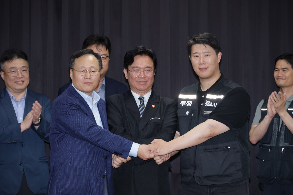 20일 경기도 수원시 장안구 경기고용노동청에서 열린 삼성전자 임금협상을 마친 후 여명구 삼성전자 DS(디바이스솔루션·반도체 사업 담당) 피플팀장과 김영훈 고용노동부 장관, 최승호 삼성그룹 초기업노동조합 삼성전자지부 위원장이 잠정 합의한에 서명한 후 손을 맞잡고 있다. / 뉴스1
