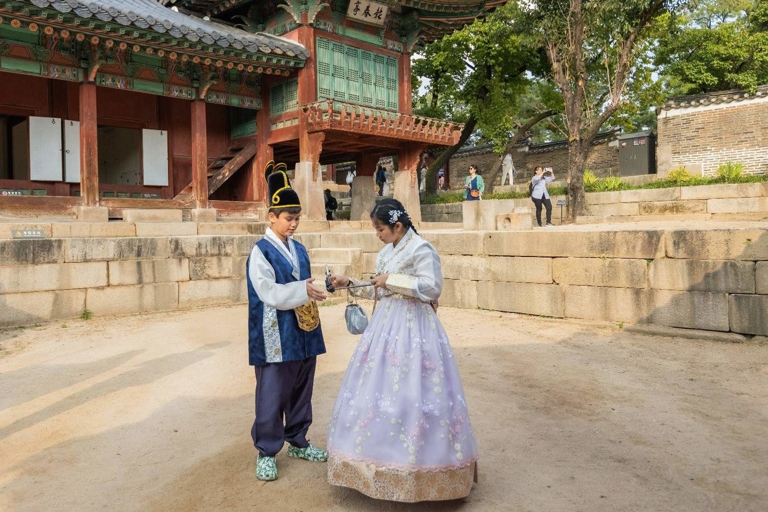 한복을 입은 관광객들이 궁궐을 배경으로 사진을 찍고 있다. / 셔터스톡