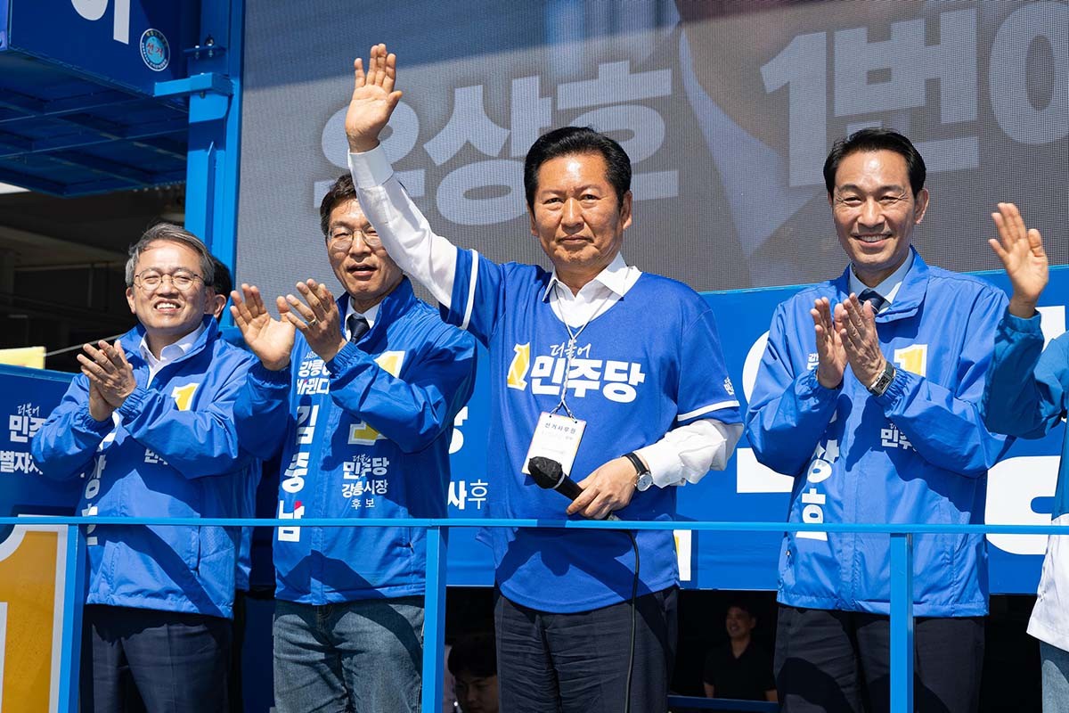 우상호 강원특별자치도지사 후보와 김중남 강릉시장 후보 지원유세에 나선 정청래 더불어민주당 대표가 22일 강원 강릉시 주문진 시장 앞에서 시민들을 향해 지지를 호소하고 있다. / 뉴스1