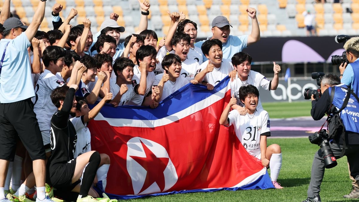 23일 오후 경기 수원시 수원종합운동장에서 열린 2025-2026 아시아축구연맹(AFC) 여자 챔피언스리그(AWCL) 결승 도쿄 베르디의 경기에서 1-0으로 승리하며 사상 첫 정상에 오른 북한 내고향여자축구단 선수들이 인공기를 들고 기념촬영을 하고 있는 모습. / 뉴스1