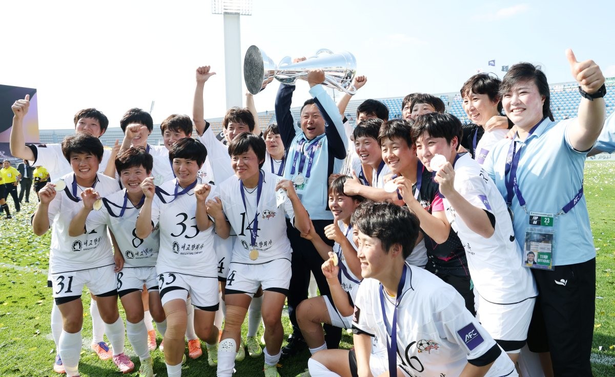 23일 오후 경기 수원시 수원종합운동장에서 열린 2025-2026 아시아축구연맹(AFC) 여자 챔피언스리그(AWCL) 결승 북한 내고향여자축구단과 도쿄 베르디의 경기에서 우승을 거둔 내고향 선수들과 리유일 감독이 트로피를 들고 환호하고 있는 모습. / 뉴스1
